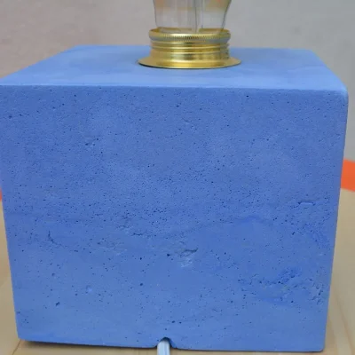 Détail de la douille dorée sur la lampe en béton bleu