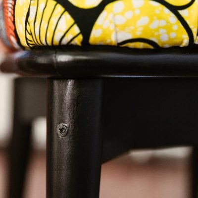Détail de la jonction entre le bois teinté noir et l'assise en tissu Wax