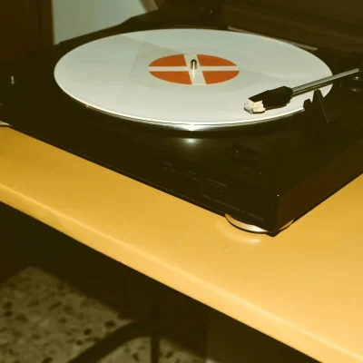 Table TV restaurée avec plateau en béton ciré jaune et platine vinyle